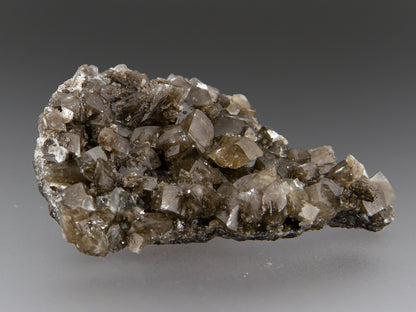 Brown calcite crystals on matrix. Rhombohedral form with waxy luster.