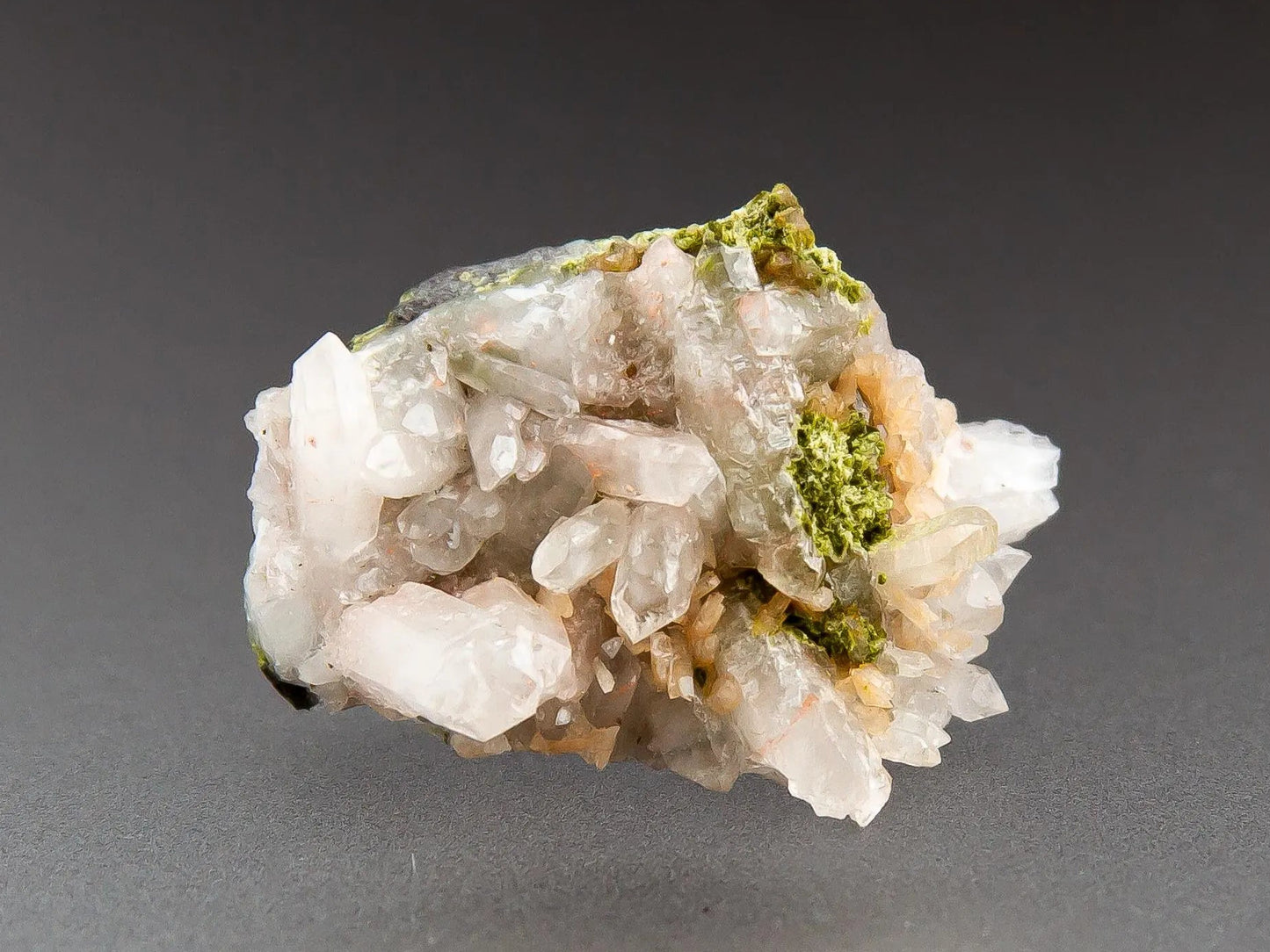 White quartz with epidote crystals on a gray background, labeled 'Adamantine Minerals'