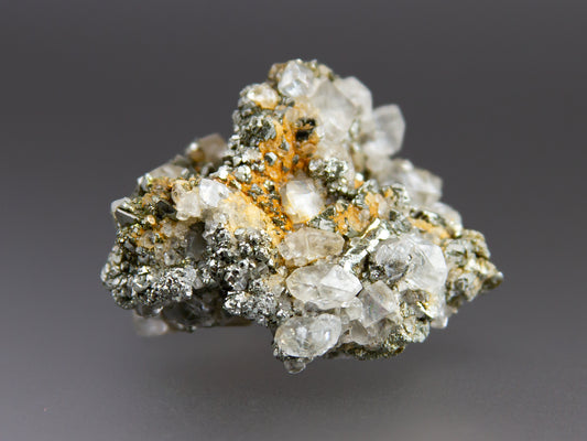 Mineral sample with crystals on a gray background