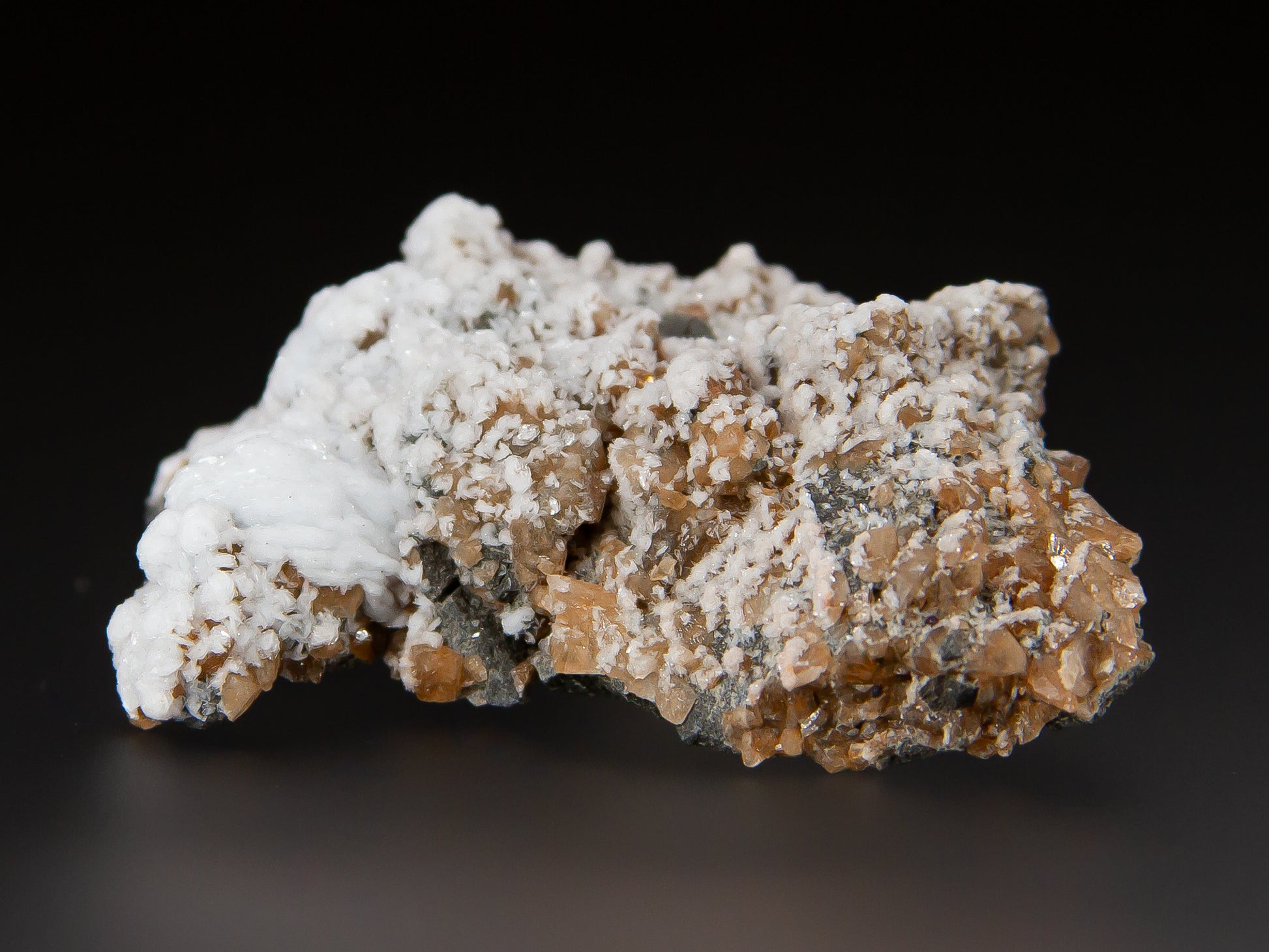 White barite crystals partially covering a layer of golden dogtooth calcites.